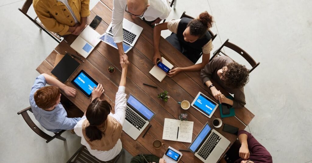 Top view of a diverse team collaborating in an office setting with laptops and tablets
