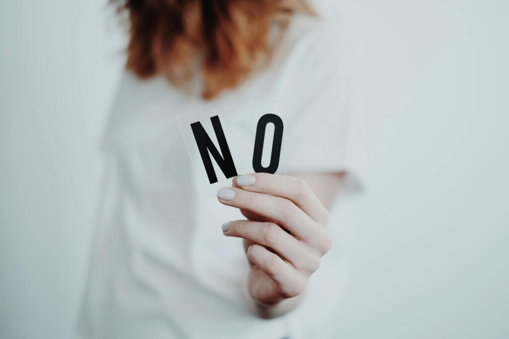 Close up of a person holding a no sign symbolizing rejection or disagreement
